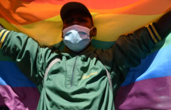 A man waving pride flag on a street march jpg
