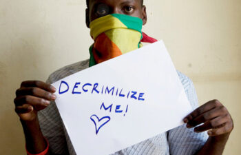 An LGBTQ member holding a placard to creatre awareness jpg